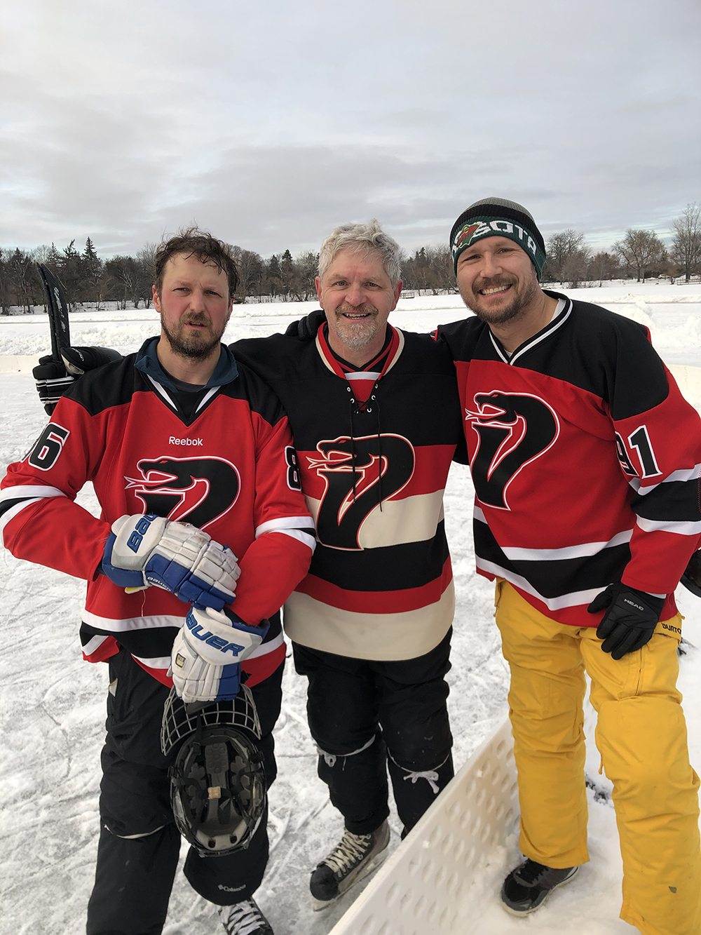 Tom Albin and two teammates suited up for a hockey game. 